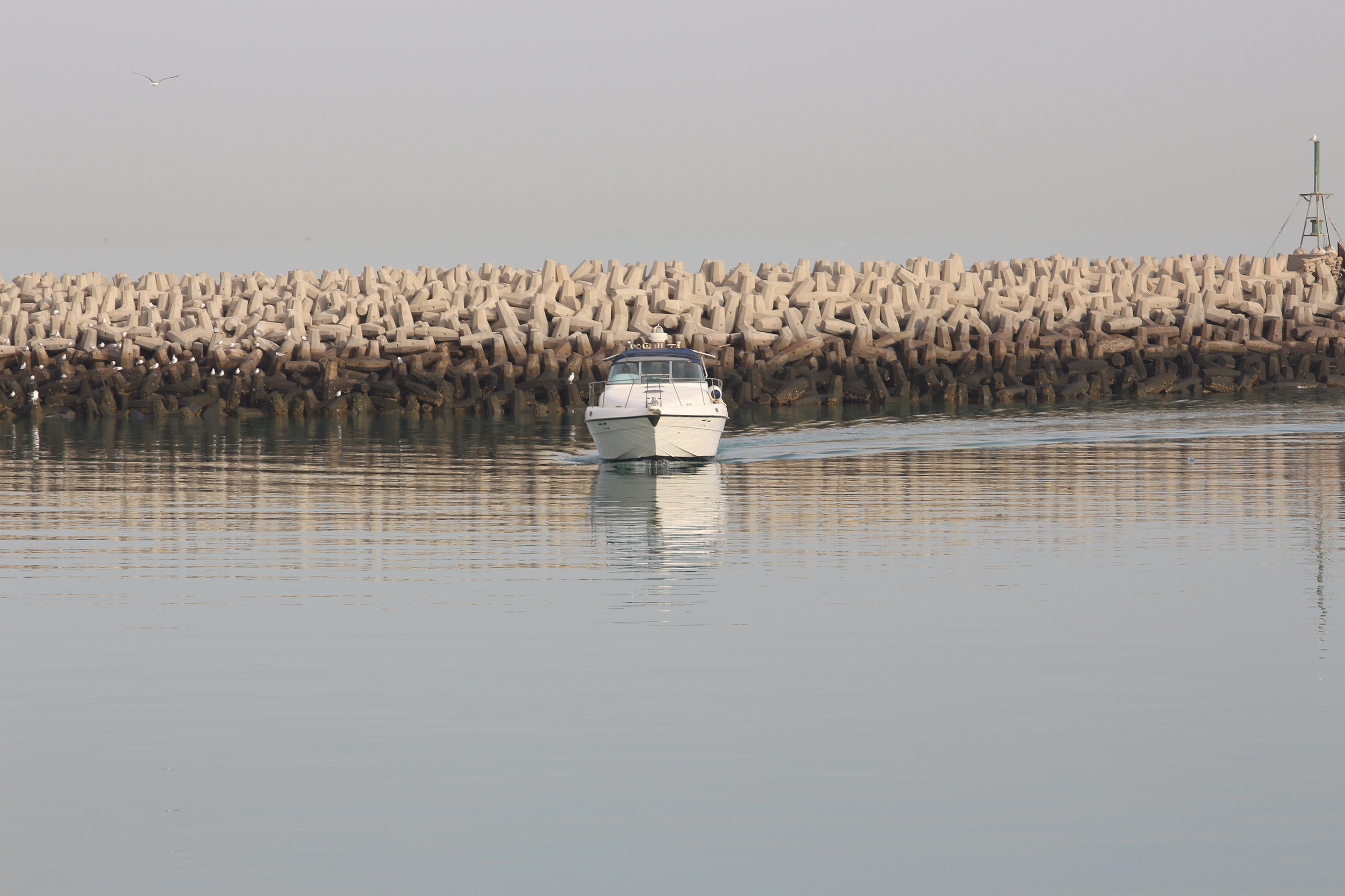 a white boat entering the kuwait port